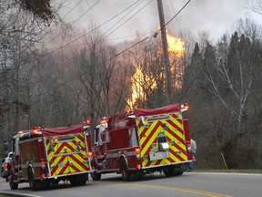 Fire crews look on as flames burn from a gas line explosion near Sissonville, West Virginia December 11, 2012. The explosion in Sissonville, about 10 miles north of Charleston, setting several houses and buildings on fire, authorities said.  REUTERS/The Charleston Gazette/Rusty Marks