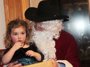 Sadie Keeley tells Santa all about her new outfit and necklace at the Municipal District of Ranchland Christmas party Dec. 7, west of Nanton, Alberta.
