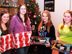 For about 90 years, the tradition of gift giving established by F.W. Schumacher has endured in the town bearing his name. Today the Schumacher Foundation ensures a very merry Christmas for every school-age child in the community. Helping to wrap the gifts for distribution next week are, from left, Larisa Golinowski, Michaelia Delich, Jordan Thiboutot and Brooke Kirley.