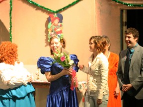 Director Stephanie McLachlan (in the blue dress) receiving flowers from her cast members after a presentation of "Dashing Through the Snow" at the Fred Speckeen theatre on Friday, Dec. 7, 2012. The show was presented by the College Town Capers community theatre group.