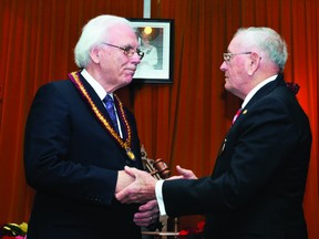 Outgoing warden Mel Campbell, right, passes the gavel to new Leeds and Grenville counties council warden Ron Holman at an inauguration ceremony held on Wednesday morning (ALANAH DUFFY/The Recorder and Times).