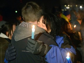 Kim Thomas embraces Mackenzie Tivendale as hundreds gather for a vigil in memory of Brandon Thomas at Mitford Pond, Dec. 8. Kim found comfort in the community response to the tragic loss of her son.