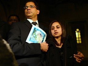 Lisha Barboza stands with her father Ben while he holds a picture of his wife, nurse Jacintha Saldanha, as they leave the Houses of Parliament in London December 10, 2012. (REUTERS/Dylan Martinez)