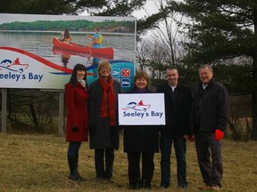 From left: Tori Watson, Cindy Healy, Peggy Sweet McCumber, Trevor Trewartha and Frank Kinsella show off Seeley's Bay's new sign and logo.