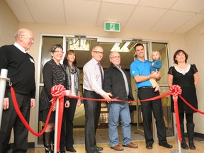 From left: Terry Wendel of Alberta Education, GGPSD board chairwoman Karen Prokopowich, Lori Anne Thiessen of Beairsto Lehners and Ketchum, Comp vice principal David Johnson, Bruce Beairsto, Mayor Bill Given (with daughter Mila) and public health nurse Miriam Bowes. Johnson cuts the ribbon on the newly-opened Health & Wellness Centre at the Composite High school on Tuesday evening. (Graeme Bruce/Daily Herald-Tribune)