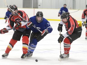 St. Mary's Mustangs Grayham Santin, centre, tries to break through between Sacred Heart Crusaders defenders Jake Colhoquon. left, and Brendan King during a game Wednesday at the Julie McArthur Regional Recreation Centre in Owen Sound.