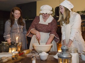 Tammy Lloyd (centre) works in the kitchen to bake cookies and wassail for guests of the Candlelight Evening with the Macphersons on Saturday night.  Dressed in period costumes and doing duties as they would have been done in the mid 1800s, Lloyd and the other volunteers strive to bring the history of the Allan Macpherson Home back to life in Napanee.