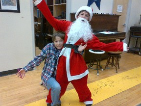 Connor Savoy, AKA Santa Claus, gets a hug from Victor Swanson, who is playing Judge Oldergary this weekend during the Good Idea Theatre's Christmas production. (Contributed Photo)