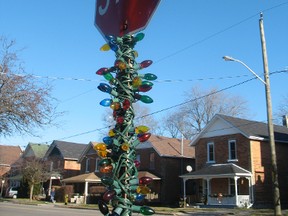 An unknown Kris Kringle strung up Christmas lights on the street signs on Chapel Street in Simcoe. Norfolk County employees removed the lights on Thursday. (SARAH DOKTOR Simcoe Reformer)