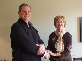 Wray Holmes, new chair of the Habitat for Humanity Seaway Valley shakes the hand of former chair, Frances Lauzon, who has handed in her resignation to retire.