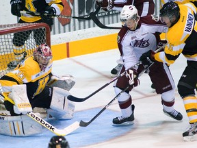 Peterborough Petes forward Luke Hietkamp is checked off the puck by Kingston Frontenacs’ Mikko Vainonen in front of Frontenacs goalie Mike Morrison during an Ontario Hockey League game in Peterborough on Oct. 11. The Frontenacs acquired Hietkamp from the Petes on Thursday. (QMI Agency file photo)
