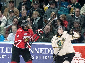 Wallaceburg's Seth Griffith, right, of the London Knights and Gemel Smith of the Owen Sound Attack keep their eyes on an airborne puck during Friday's game at Budweiser Gardens in London. (CRAIG GLOVER/QMI Agency)