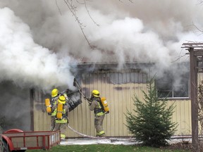 Firefighters with Harwich North Fire Station No. 12 pull back the metal cladding to put out a shed fire at a home on Maynard Line, just east of Communication Road, near Chatham, which was called in around 1 p.m. on Saturday.  ELLWOOD SHREVE/ THE CHATHAM DAILY NEWS/ QMI AGENCY