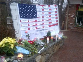 A makeshift American flag with the names of the victims of last week's horrific shooting sits on Newtown's main street. (JOE WARMINGTON, Toronto Sun)