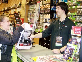 Terri Gibeault accepts her purchase from Phillip Melo, assistant manager of Game Stop in the Cornwall Square, after buying a Christmas gift for her son last year.
File photo