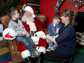 Santa Claus listens to five year-old Antonio Santos, 5, as his brother Joseph, two, doesn’t want to have anything to do with the jolly old elf, at the Cataraqui Centre on Friday. Holding Joseph is mom Michelle. (Ian MacAlpine The Whig-Standard)
