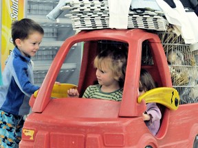 Josh, 3,  plays doorman to his sisters Katy, 4, centre, and Kylee, 2, while they wait in the long lines with a car-cart full of deals at Zellers, which will close for the final time when the last item is sold Monday December 17, 2012 in Chatham, On. Target, who bought the Zellers chain, plan to open an expanded store in the same location in June 2013. DIANA MARTIN/ THE CHATHAM DAILY NEWS/ QMI AGENCY
