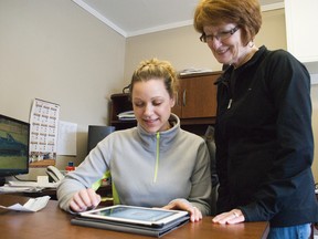 Angela Wollbeaum, execuative director of Portage Arc shows an iPad app to Winnie Walsh, member of the UCT.