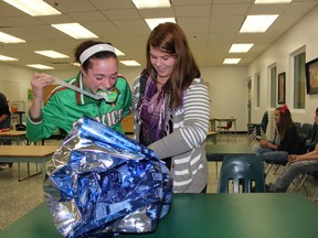 Emily Alsbach and Morgan Rink took part in the Siamese wrapping challenge at MUCC yesterday, Monday, December 17. They each used one hand to wrap a basketball.