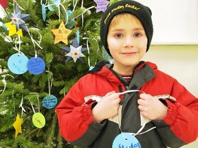 Six year old Ryan Morris makes a Christmas decoration with an...
