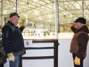 John Blake and Nanton Minor Hockey president Clem Armstrong stretch out a sample of the transparent mesh that will soon replace the black arena mesh at the Tom Hornecker Recreation Centre.