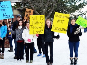 Pictured left to right: Danielle Gomes, Madeline Weichel, Teaghan Johnston, and Latashe Millette show off their signs in front of the school while they wait for more students to take part.