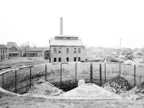 Part of the Scott Studio fonds, courtesy of the Elgin County Archives. 
In this 1936 photo looking west to Mondamin St. between Curtis and Scott streets, the former city gas plant is being demolished. The plant made artificial gas from coal for lighting and cooking. The circular structure in the foreground is the base of a gasometer, which stored gas for distribution. (SCOTT SEFTON FONDS Elgin County Archives )
