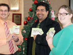 Neil Siblall, centre, accepts $1,000 in Visa gift cards from Daily Press multimedia sales consultants Casey Swann and Lee Vail-Laramore. Siblall was the grand prize winner in The Daily Press’ annual Cash for Christmas contest.