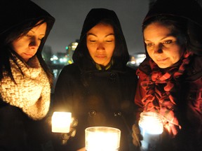 From left, Kelly Adams, Michelle Deabre and Jodie Swinson take part in Tuesday night's candlelight vigil on Blockhouse Island for the victims of the Newtown, CT shootings. RONALD ZAJAC The Recorder and Times