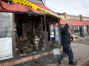 An investigator from the Ontario FIre Marshall's office surveys fire damage at Blue Lagoon II on Oxford Street East in London on Sunday January 8th, 2012. (CRAIG GLOVER, The London Free Press)