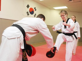 Cassandra Senchuk, who received her black belt Tuesday, spars with instructor Steve Gagne, as training partner Payton Patterson looks on. GINO DONATO/THE SUDBURY STAR/QMI AGENCY