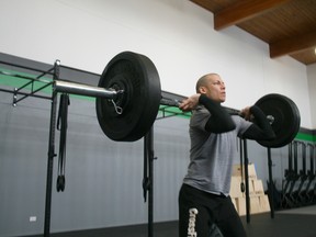 Dave Emery of Crossfit Core K-Town performs a Clean & Jerk, two motions bringing one’s body weight to the shoulders, then above the head. Emery and members of his new gym will perform one Clean & Jerk for every gently used winter jacket donated by Dec. 23. 
JON THOMPSON/Daily Miner and News