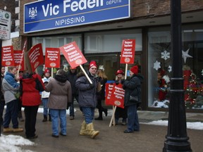 Striking members of the Elementary Teachers' Federation of Ontario picket in front of Nipissing MPP Vic Fedeli's office Tuesday. (PJ WILSON The Nugget)