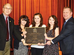 Griffiths-Scott Middle School held its offical opening Dec. 13, 2012, in Millet north of Wetaskiwin. Several presentations were made on the night, including a provincial bronze commemorative plaque. Pictured are: Former Wetaskiwin-Camrose MLA LeRoy Johnson, left, three students – Brianna Miner, Mya Congi and Emily Trent – and school prinicipal Frank Heinrichs.