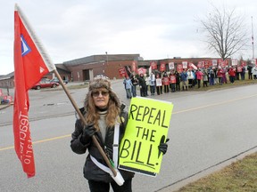 Bluewater Elementary Occasional Teachers' Local chief negotiator Kathy McCarrel stands with flag in hand for a photo across the street from Kincardine's Huron Heights Public School during the one-day strike action planned by the Elementary Teachers Federation of Ontario in protest of Bill 115 on Wednesday, Dec. 19, 2012. About 100 teachers walked the picket line in protest of the boundaries Bill 115 will put on their collective bargaining rights if it becomes law when the provincial government returns to session in 2013. (TROY PATTERSON/KINCARDINE NEWS)