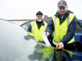 Allen Magee, front, along with Chuck Lane explain how the Lock it or Lose it campaign works at the Metro parking lot Tuesday afternoon. Beginning Thursday, the Community Policing volunteers will be on the hunt for vehicles that have valuables in sight and could be a potential target for thieves. 
Emily Mountney Trentonian