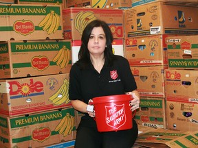 Alice Wannan of the Salvation Army with a collection kettle among boxes of food that will be organized into Christmas hampers.