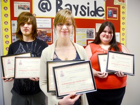 Bayside Secondary School students hold their Remembrance Day poster, essay, and poem contest awards on Tuesday at the school. Austin Brooks (left) won for his remembrance poem, Melissa Mourez (front) won for her black-and-white poster and Cassidy MacDonald won for her essay. 
Emily Mountney Trentonian