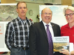 A joint land reclamation research program was launched by the Glenbow Ranch Park Foundation and Shell on Monday. Here  foundation Chief Executive Officer Andy Crooks, right, presents Louis Auger, Shell vice-president of production north, with a copy  of the recently published book on the Glenbow Ranch Provincial Park while foundation director Tim Harvie looks on.