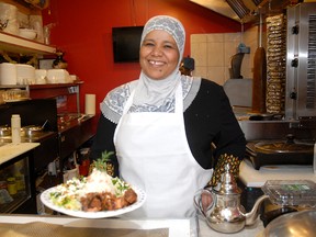 Mona Awadalla serves a plate of camel meat at the Taste of Egypt restaurant in the Farmers’ Market. The restaurant now serves camel meat every Thursday . (Patrick Callan/Daily Herald-Tribune)