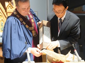 Mayor Neil Ellis and Gunpo mayor Yoon-joo Kim open a gift given to the city by the eight-member delegation from the South Korean city. The delegation arrived in Belleville Wednesday and will remain in the city until Sunday. W. BRICE MCVICAR/THE INTELLIGENCER/QMI AGENCY