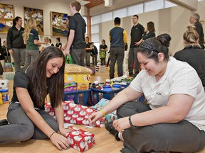 BRIAN THOMPSON, The Expositor

Cristina Poppa (left) and Shayla Maisano, both Grade 12 students at St. John's College, wrap a gift as students assemble hampers of food, household items and gifts for 31 families in need for the school's Christmas Angels program.