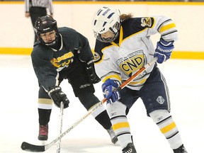 Confederation Chargers Ryleigh Boivin, left, fights for the puck with Joelle Belanger of the College Notre Dame Alouettes, during girls high school hockey action from the Carmichael Arena on Wednesday afternoon.