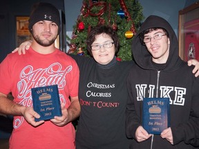 Trenton Curling Club President Barb Flieler presents H.E.L.M.S. curling bonspiel winners Dustin Burchaw and Kevin Clark with their first-place plaques.