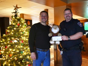 Pier Donnini (left) donated $3,500 to the DARE program which was received by constable Chris Coles (right) on Dec. 8 at The Queen’s Bar and Grill.