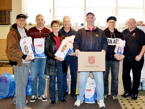 Pictured (left to right) Ron Moss, Ken Underwood, Erin Zorzi, Peter Harrison, Bob Lunney, Dan Murawsky and Ed Giles posing with all their donations to the food bank.