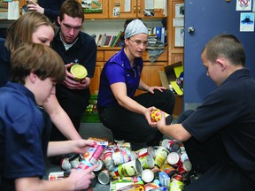 Students and staff at St. Mary Catholic High School sort donated food items Wednesday morning for two area food banks. Clockwise from left are Gavin Noyes, Meredith Conboy, Collin Reynolds, teacher Kathleen Pasic and Aaron Birt. RONALD ZAJAC The Recorder and Times