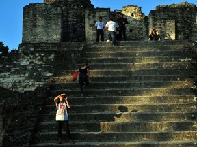 Tourists observe the last sunset at the end of a 5,200-year era in the Mayan Calendar in the Tikal archeological site in Peten department, 560 km north of Guatemala City, on December 20, 2012. Ceremonies will be held here to celebrate the end of the Mayan cycle known as Bak'tun 13 and the start of the new Maya Era on December 21. AFP PHOTO/Hector RETAMAL