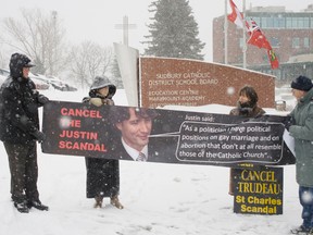 Pro-life activists picket outside the Sudbury Catholic District School Board with a banner featuring Justin Trudeau's face and a quote saying: "As a politician I have political positions on gay marriage and abortion that don't at all resemble those of the Catholic Church."