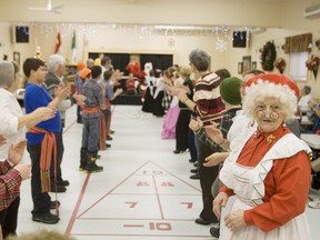 Mrs. Claus waits her turn to take part in a traditional folk dance at the Club d'age d'or in Hanmer with some Grade 7 students from Jean Paul II Catholic Elementary School on Thursday afternoon.